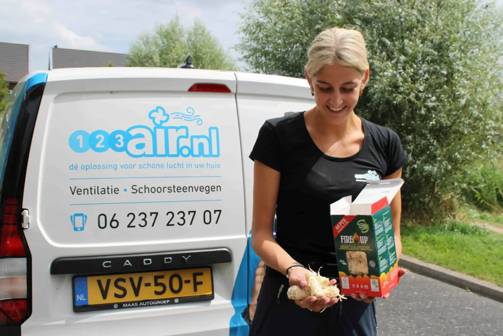 Medewerker van 123Air naast servicebus voor ventilatie- en schoorsteenreiniging