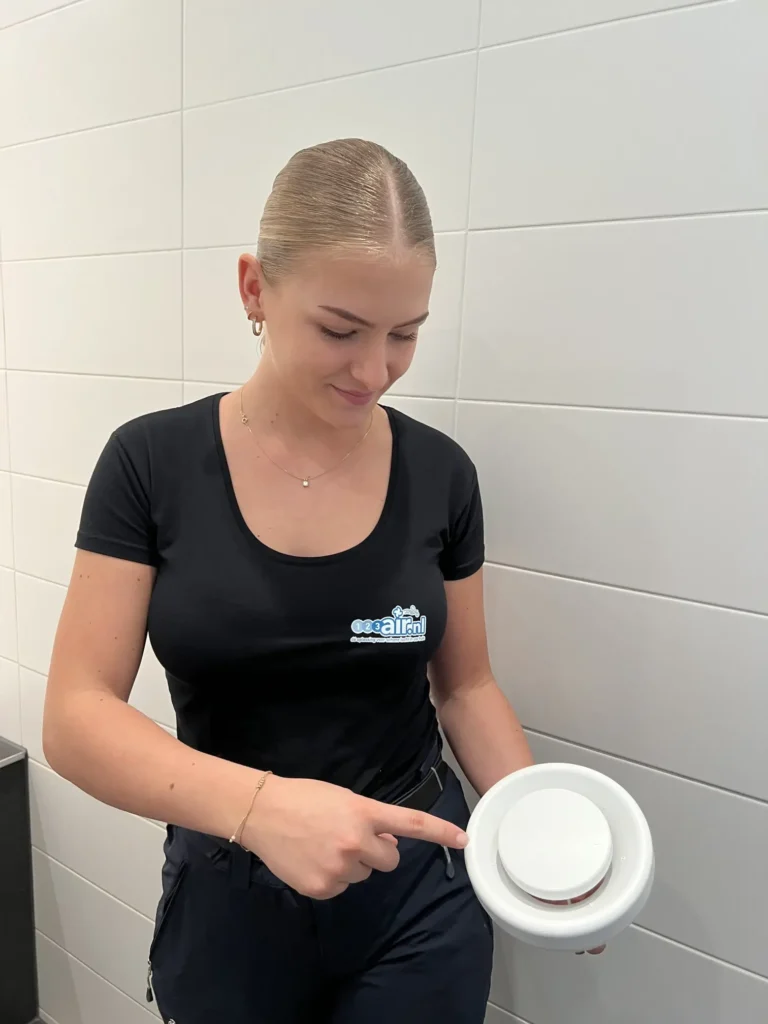 Medewerker van 123Air toont schone ventilatieventiel na onderhoud