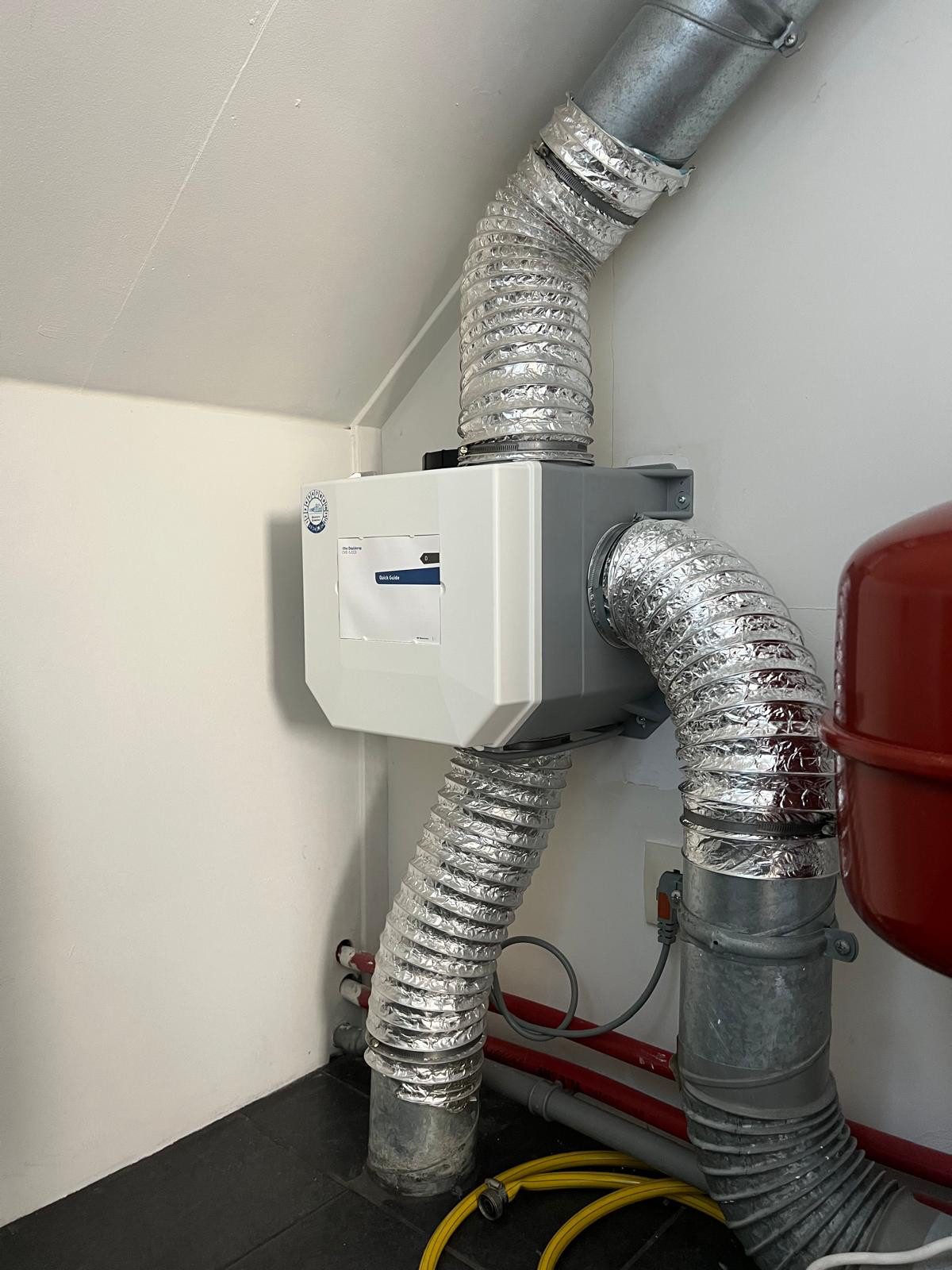 Nieuw geplaatste Itho Daalderop ventilatie-unit met aangesloten flexibele luchtkanalen in een technische ruimte